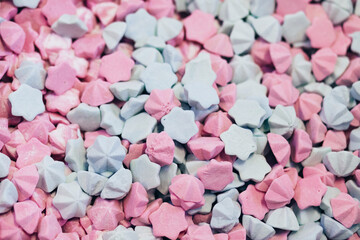 Industrial production of sweeties. Light pink and mint marshmallows background, sugar confetti