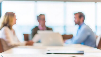Obraz premium A blurred meeting room scene with a team discussing business strategies around a conference table. 