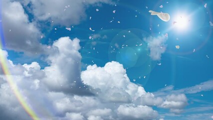 春ひらひらとたくさんの花弁が舞い落ちる空の風景　青空と雲の背景　自然・お祝い・希望・結婚式・ウエディング・アウトドア・春・出発・入学・入社のイメージ　太陽の光と旅行の雰囲気