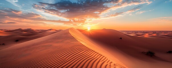 Dramatic desert dunes under a vibrant sunset