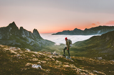 Man backpacker hiking in mountains alone outdoor active lifestyle travel adventure vacations sunset Norway landscape