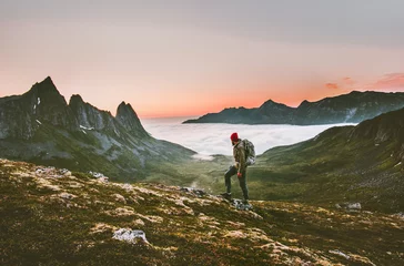 Fototapete Rund Man backpacker hiking in mountains alone  outdoor active lifestyle travel adventure vacations sunset Norway landscape © EVERST