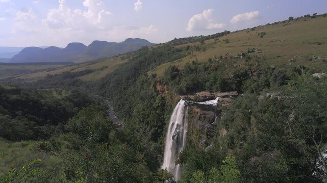 Hazy green landscape: Shallow Lisbon River waterfall into narrow canyon