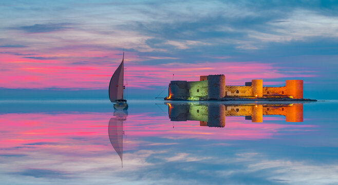 The maiden's castle (Kiz Kalesi) with lone yacht at twilight blue hour - Mersin, Turkey