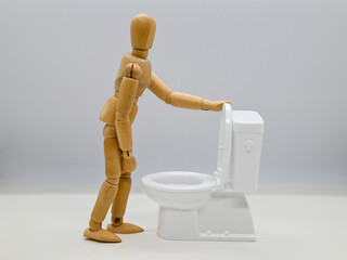 トイレの蓋を開けるデッサン人形