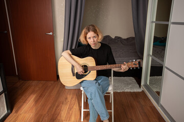 Woman playing acoustic guitar at home, person practicing musical skill, indoor guitarist strumming...