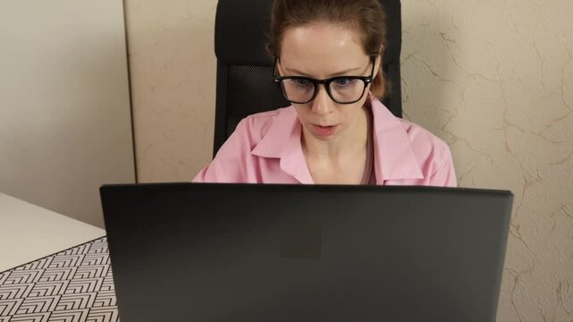 surprised woman in office at laptop, casual reaction home, female computer work