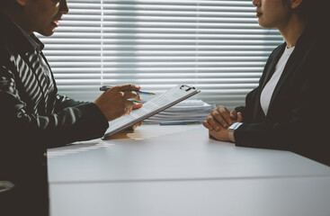 Businessman presenting contract details to businesswoman during an office meeting, discussing terms and conditions of the agreement in a professional and collaborative environment