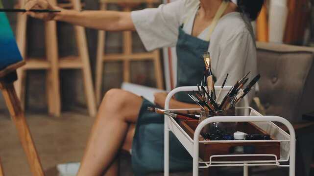 Brush on artist's canvas with mixed paints, closeup