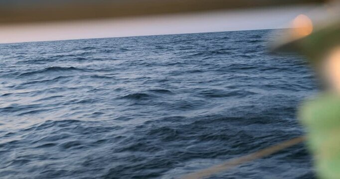 Ocean seen across an out of focus winch on a sailboat crossing the Bay of Biscay