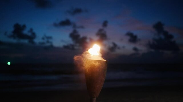 Tiki Lantern Flame Torch on beach,island on warm summer night waving on ocean breeze.summer background