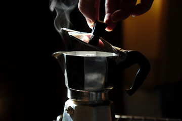 Coffee beans in Moka pot and smoke.Brewing black moka coffee using moka coffee maker	