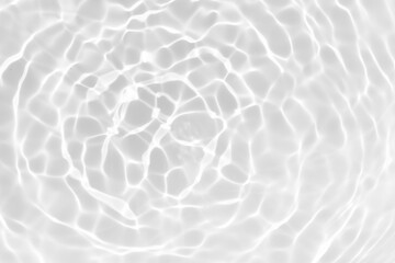 Obraz premium White water with ripples on the surface. Defocus blurred transparent white colored clear calm water surface texture with splashes and bubbles. Water waves with shining pattern texture background.