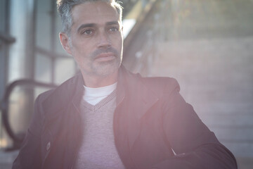 Entrepreneur with gray hair in sunlight with serious demeanor