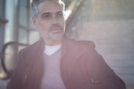 Entrepreneur with gray hair in sunlight with serious demeanor