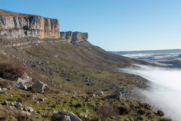 Vista de la ladera sureste de la Peña Amaya sobre la que asciende la niebla desde las estribaciones más bajas. Tomada en Amaya, Burgos, en diciembre de 2024.