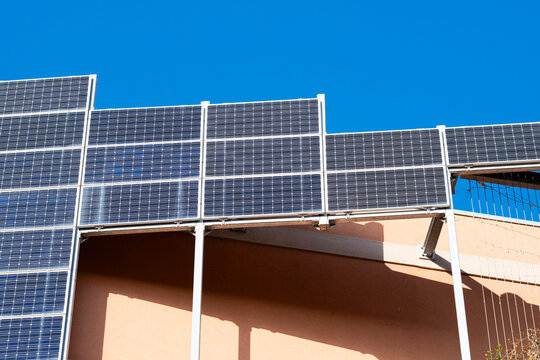 A row of solar panels positioned atop a building captures sustainable energy efforts, showcasing the synergy between modern architecture and renewable energy sources.
