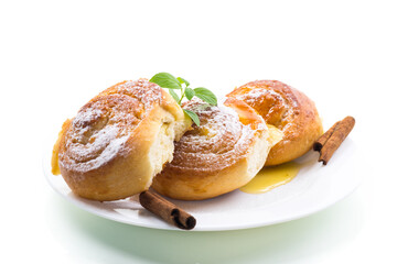 Baked goods. Sweet buns with cottage cheese filling and honey in a plate isolated on a white background