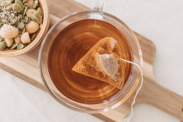 Set of mixed beans and hot tea on wooden plate.