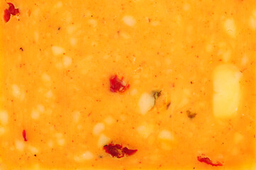 Cheddar cheese slice with mixed peppers and spices flavour background texture