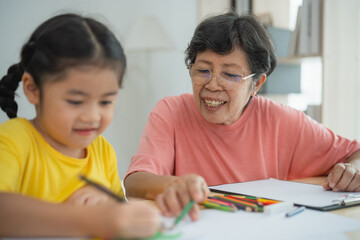 Heartwarming Scene of a Grandmother and Granddaughter Bonding Through Art and Creativity in a Cozy Indoor Setting with Bright Natural Lighting