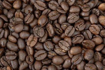Close-up of roasted arabica coffee beans.Heap of coffee beans stacked  prepare making menu in the cafe by machine ready to be brewed into a delicious cup.Textured background.