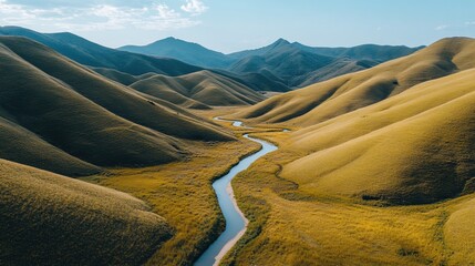 Fototapeta premium Serene River Winding Through Golden Rolling Hills Scenic Mountain Landscape