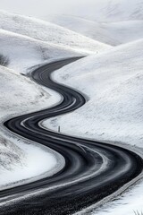 Winding snowy road through hills.