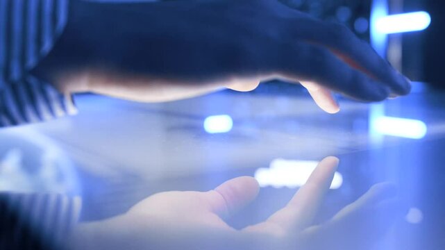 Illuminated and interactive touch screen table during a man hand using it on a close-up view.
