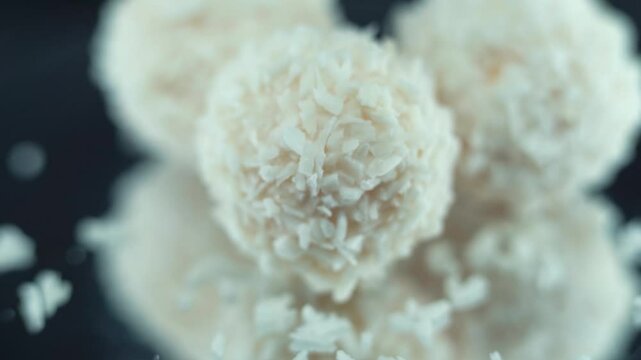 Macro shot of tasty Raffaello bonbons on a rotating stand, coconut chips, white coco dessert, smooth movement 120 fps slow motion video