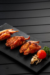 Fried chicken wings on a black slate, Chinese cuisine