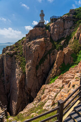 Fototapeta premium Scenic Lighthouse on Rocky Cliff Overlooking the Ocean