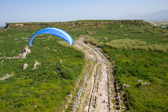Aerial view of ancient ruins and lush greenery in a scenic valley, Perge, Antalya, Turkey.