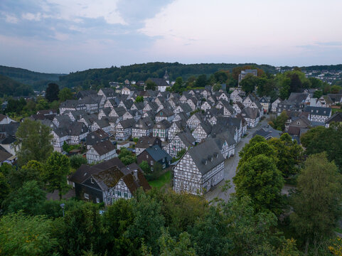 Aerial view of picturesque half-timbered houses in a charming village surrounded by greenery, Freudenberg, Germany.