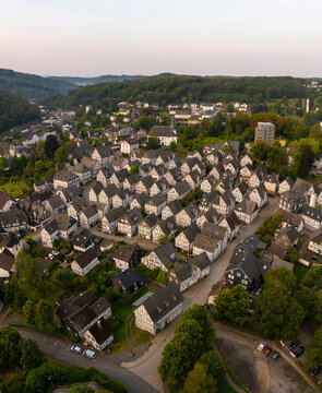 Aerial view of historic half-timbered houses in a picturesque village surrounded by trees, Freudenberg, Germany.