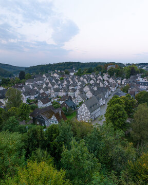 Aerial view of historic half-timbered houses in a picturesque village surrounded by trees, Freudenberg, Germany.