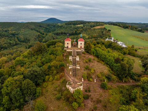 Aerial view of historic church on a hill surrounded by autumn forest and trees, Ostre, Czech Republic.