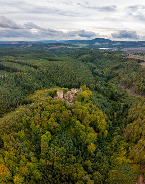 Aerial view of the abandoned medieval Burg Helfenburk castle surrounded by lush autumn forest, Usti nad Labem, Czech Republic.