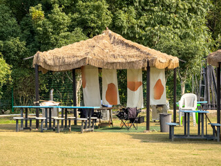 Serene Outdoor Pavilion with Thatch Roof Surrounded by Greenery