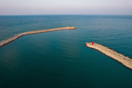 Aerial view of a beautiful coastal scene with a serene pier and a majestic lighthouse, Trani, Italy.