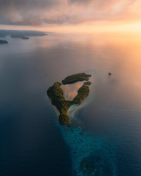 Aerial view of beautiful Kididiri Resort island at sunset with serene ocean and tranquil sky, Tojo Una Una Regency, Indonesia.