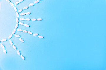 White tablets in the shape of the sun on a blue background. Copy space