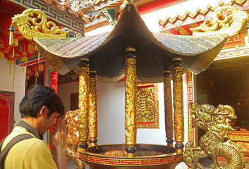 People Paying Respect after Placing Incense Sticks in the Burner at a Chinese Buddhist Temple