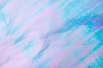 Obraz premium An abstract background featuring pastel hues of pink and blue with a textured crumpled paper effect.
