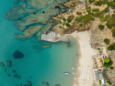 Aerial view of masua beach with turquoise water and rugged cliffs, iglesias, italy.