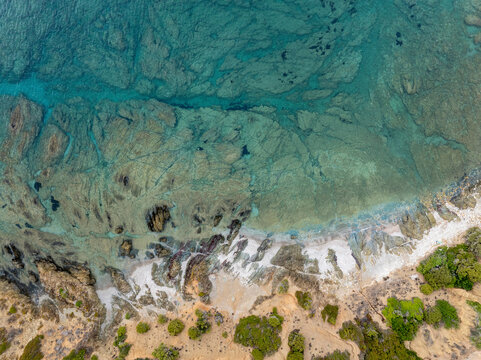Aerial view of masua beach with turquoise clear water and rocky coastline, Iglesias, Italy.