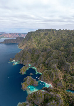Aerial view of beautiful tropical island coastline with serene ocean and scenic mountains, Banuang Daan, Coron, Philippines.