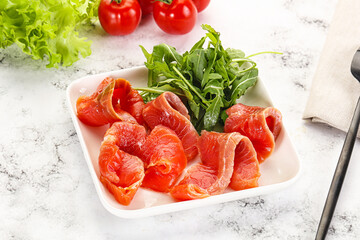 Sliced salmon with fresh arugula
