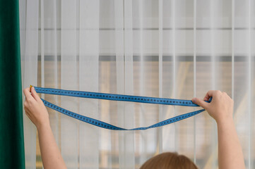 Obraz premium Dekoratorka wnętrz mierzy okno firanki i zasłonki, wykończenie pokoju 