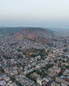 Aerial view of Ganesh Ji Temple surrounded by vibrant buildings and hills, Subhash Nagar, Jaipur, Rajasthan, India.